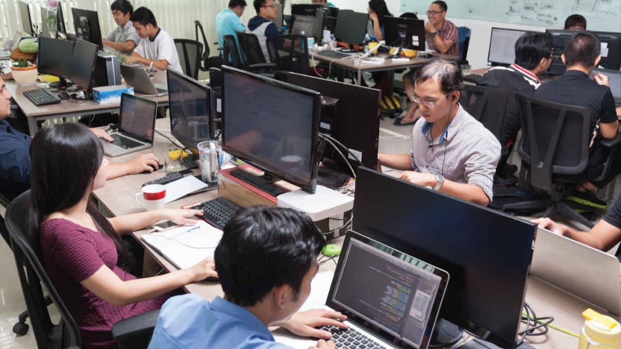 a large group of people working at their desktops with computers