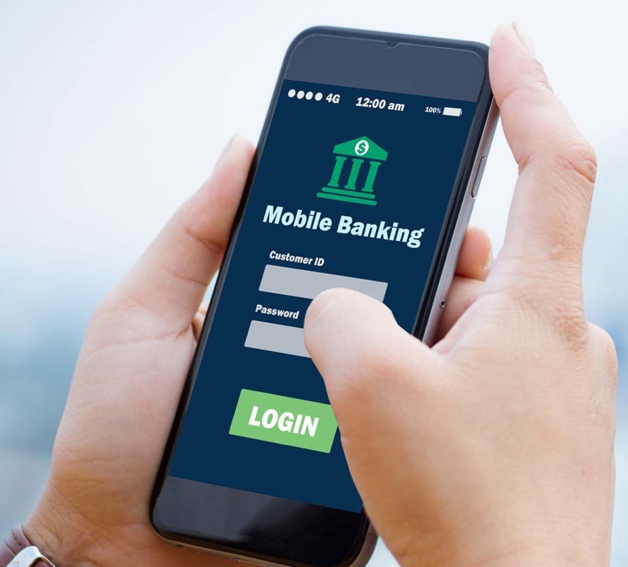 A man accesses a bank with a mobile phone in his hand.