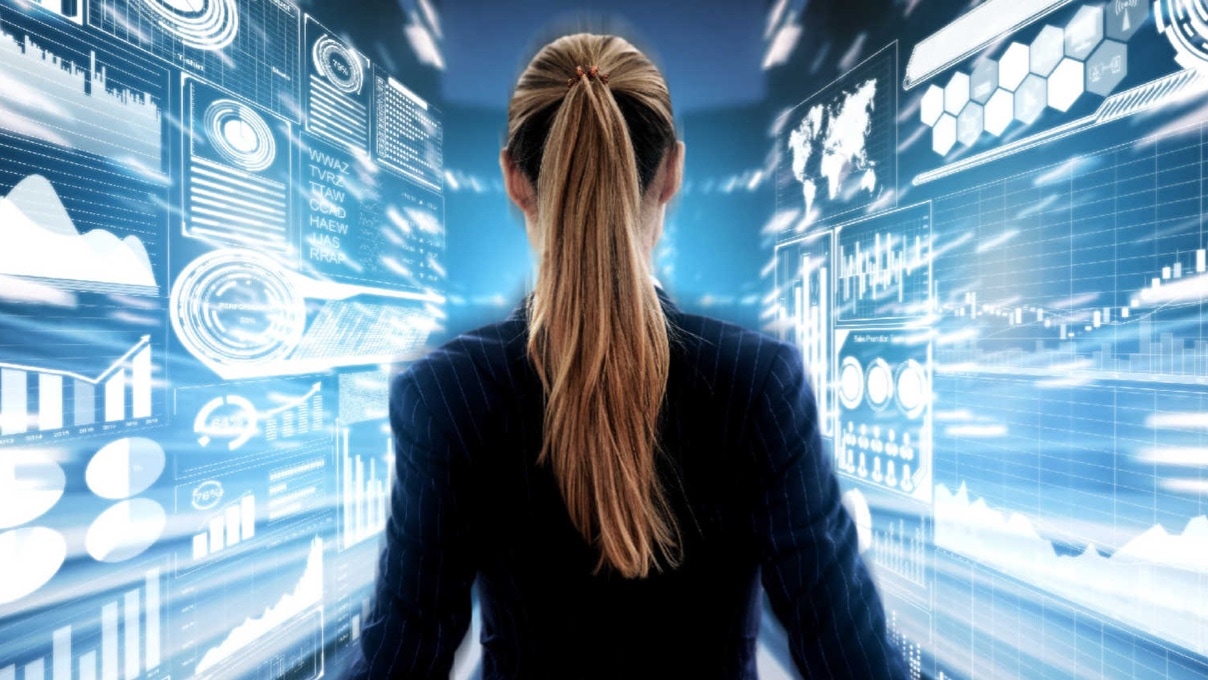 A professional woman in a business suit analyzes data displayed on a screen, showcasing her focus and expertise.