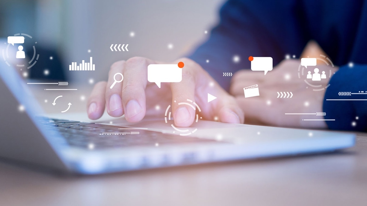 a man's hand typing on a laptop and some white icons