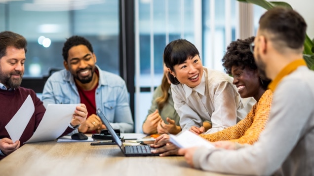 Multiethnic colleagues at a conference table working around the laptop