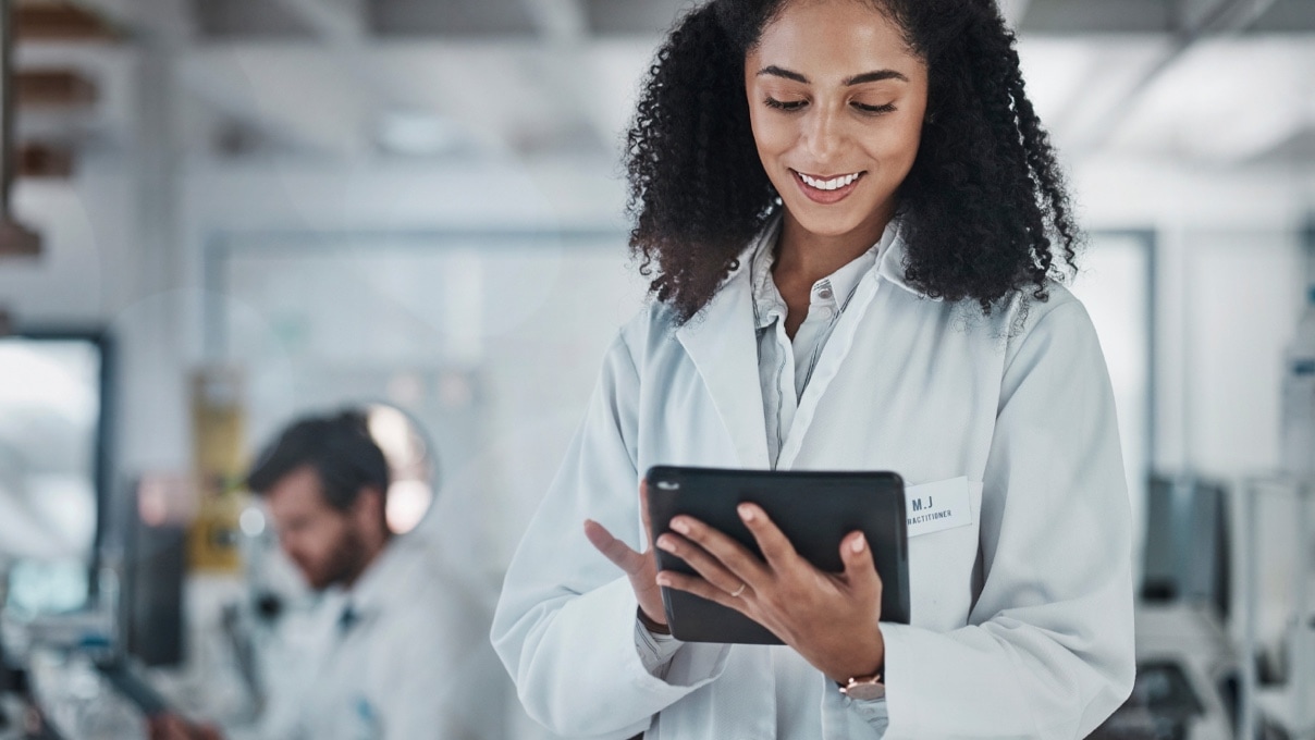 A young female doctor interacting with a tablet in her hands