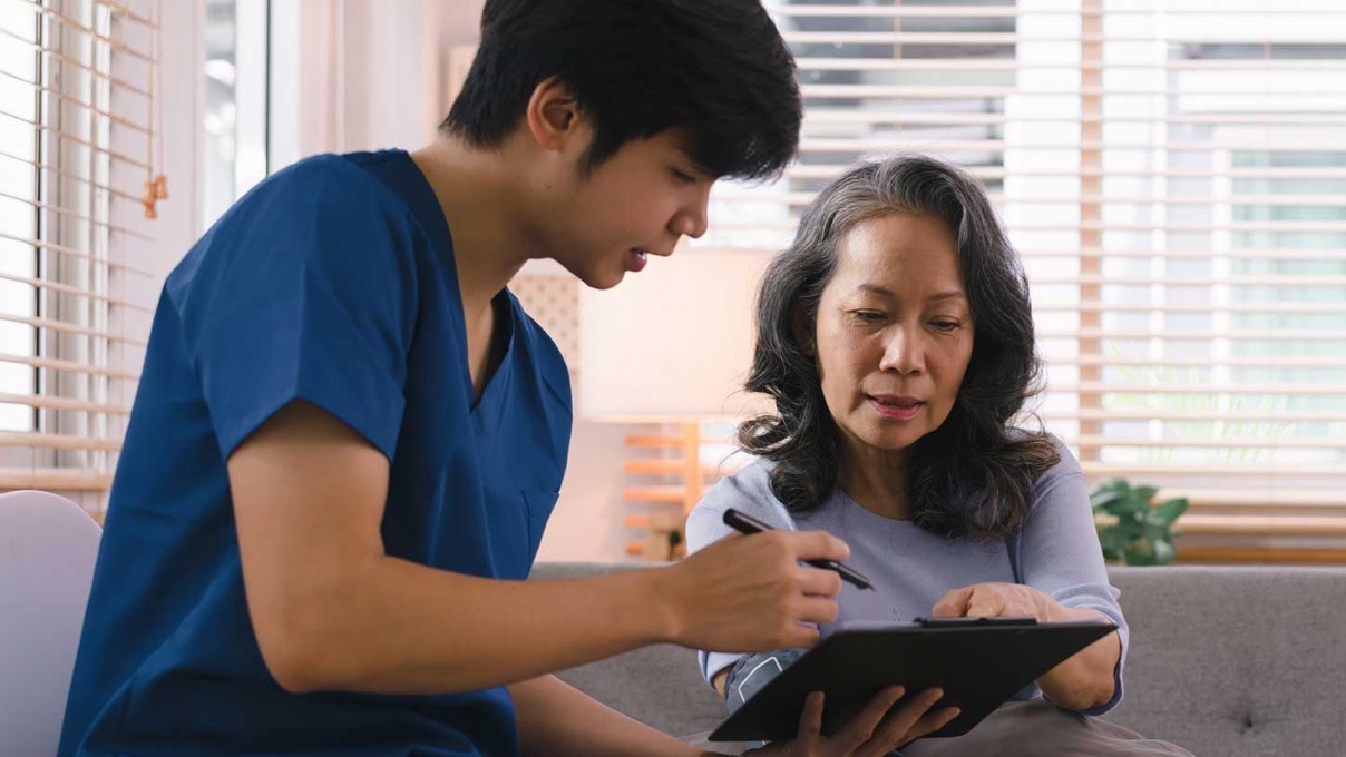 A male nurse showing results to an elderly woman