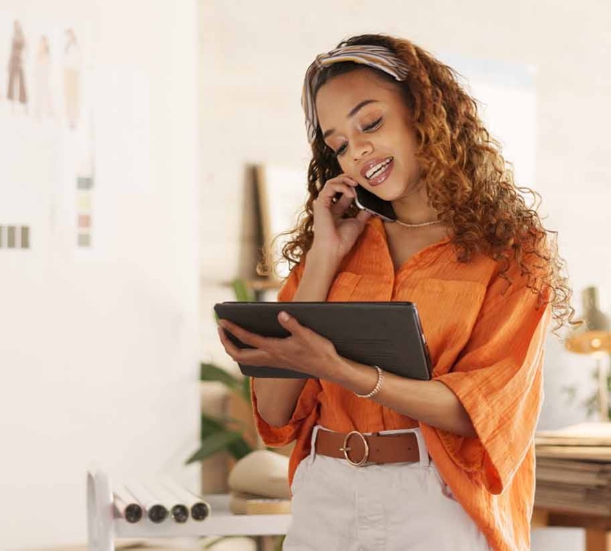 woman on the phone looking at tablet in a fashion design studio