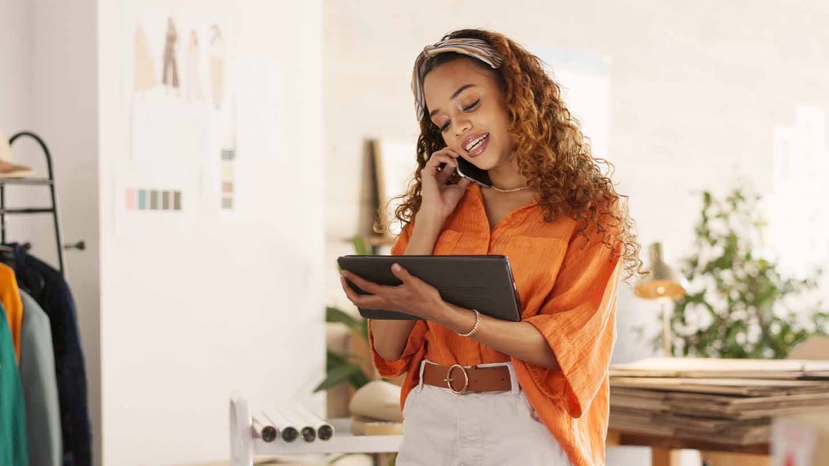 woman on the phone looking at tablet in a fashion design studio