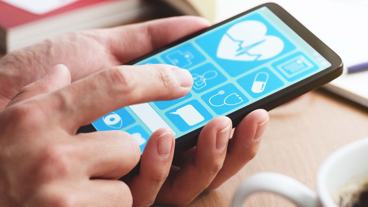 A man interacting with the screen of his mobile device with a health app.