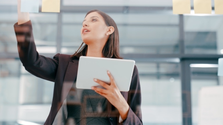 A young businesswoman using a digital tablet during a brainstorming session in a modern office