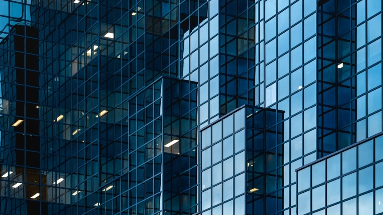 The modern blue glass facade of a building